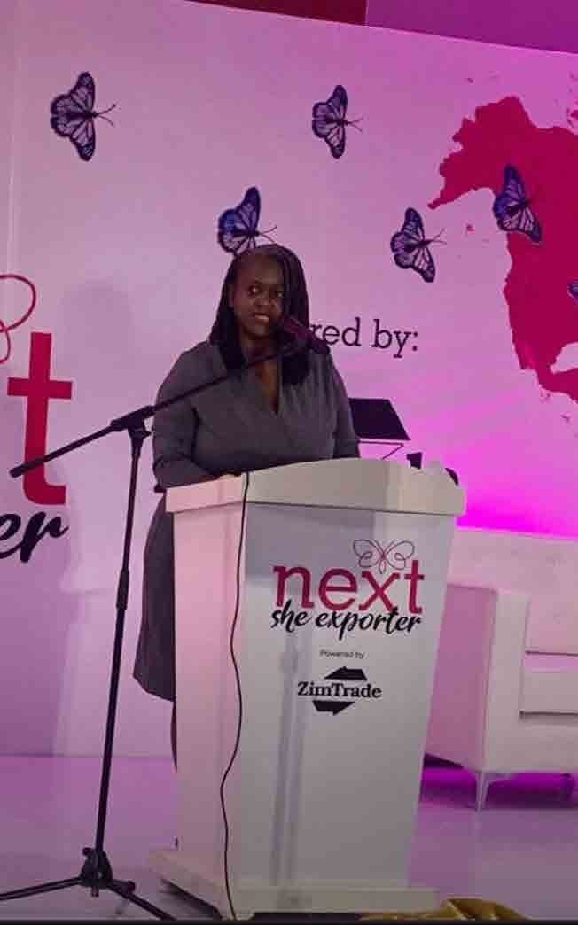 Clara speaking at a Next She Exporter podium.