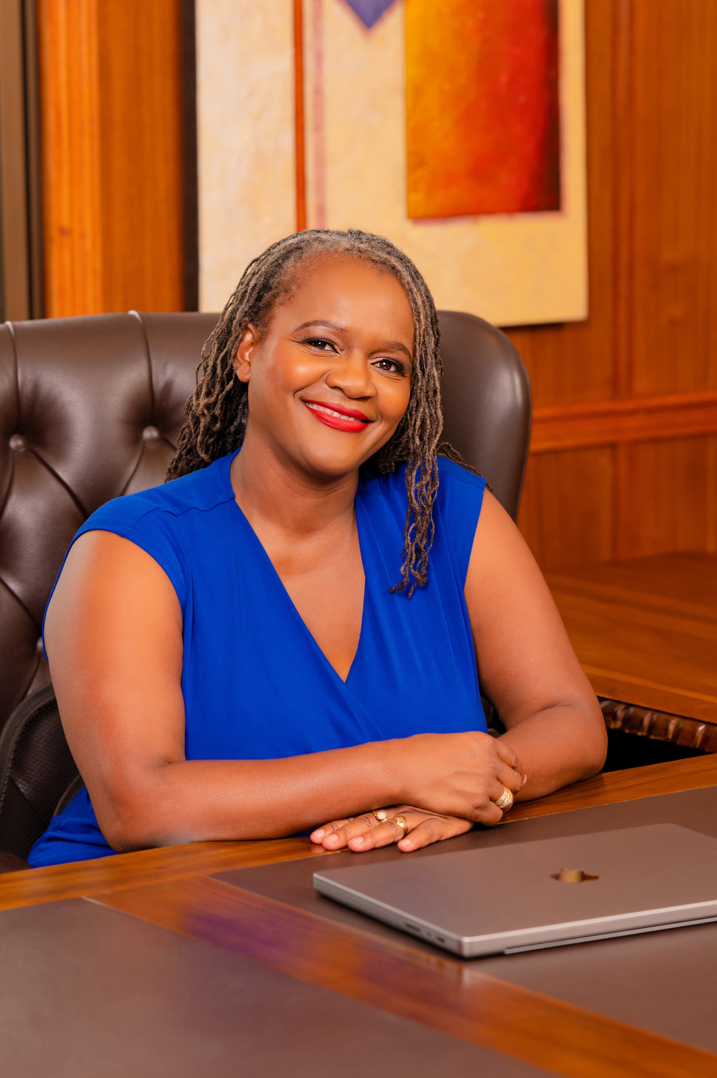 Clara Mlambo seated at an office desk.